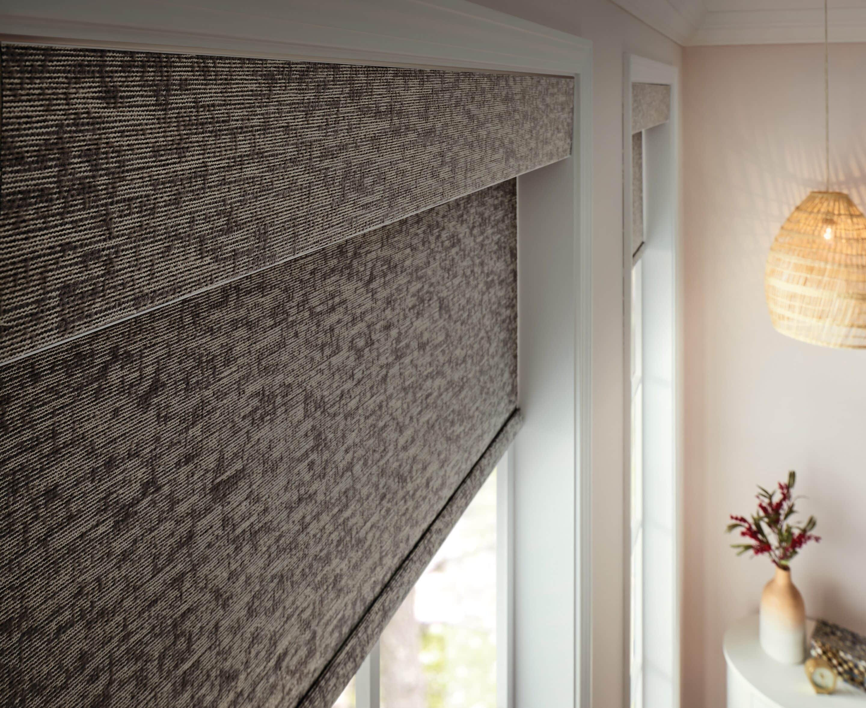 Textured neutral roller shades add warmth and dimension while complementing the surrounding décor.